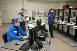 Машинисты технологических компрессоров (справа и слева) и диспетчер газокомпрессорной службы за работой на Главном Щите Управления Приобской промплощадки