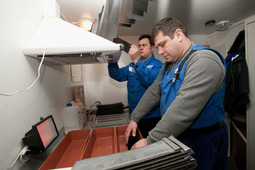 Специалисты Лаборатории неразрушающего контроля производят проявку рентгеновских снимков в  передвижной авто-лаборатории.