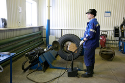 Специалист производит монтаж колеса для грузового автомобиля